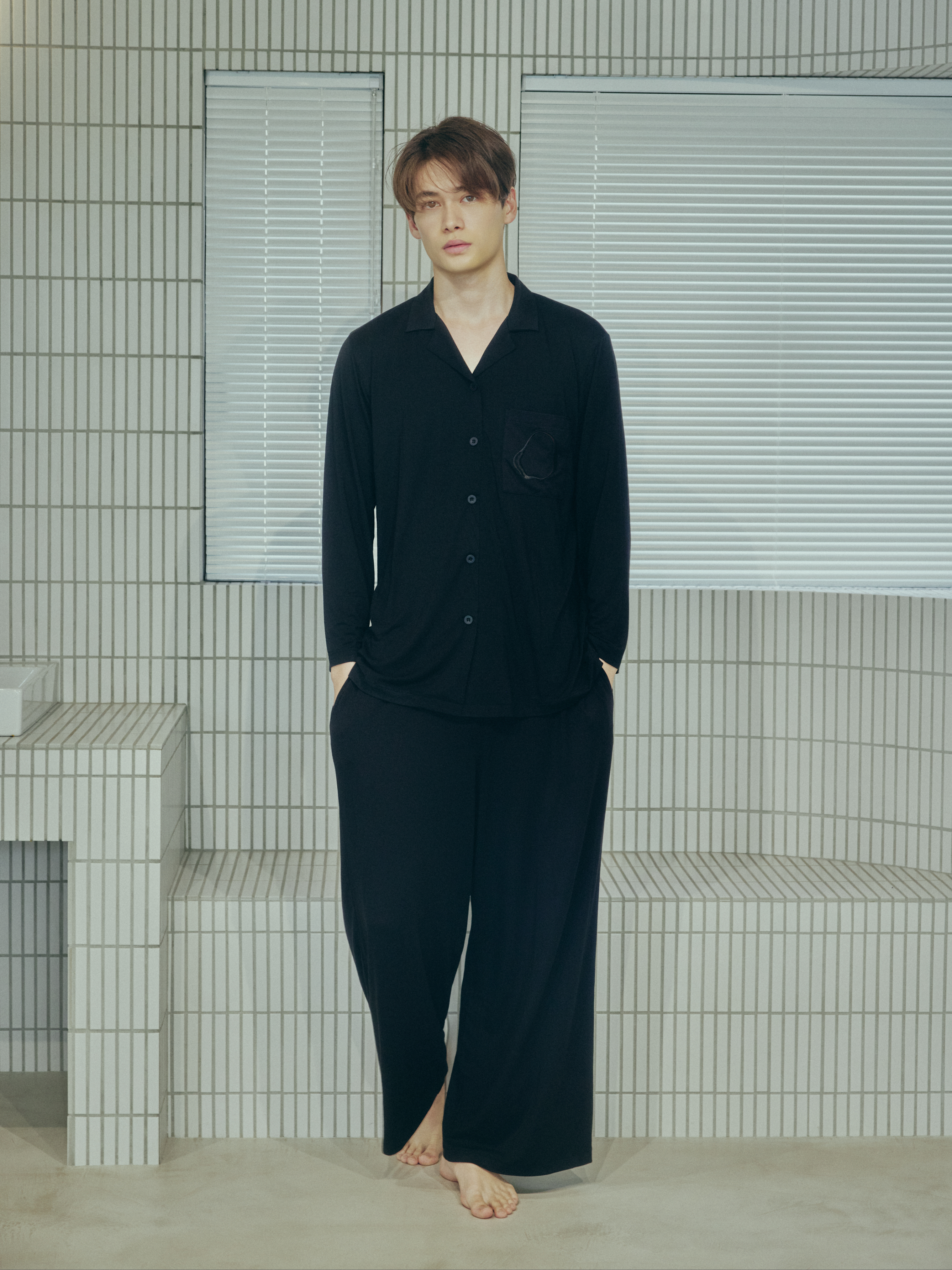 黒いAMBIENTパジャマを着た男性モデルの全身写真