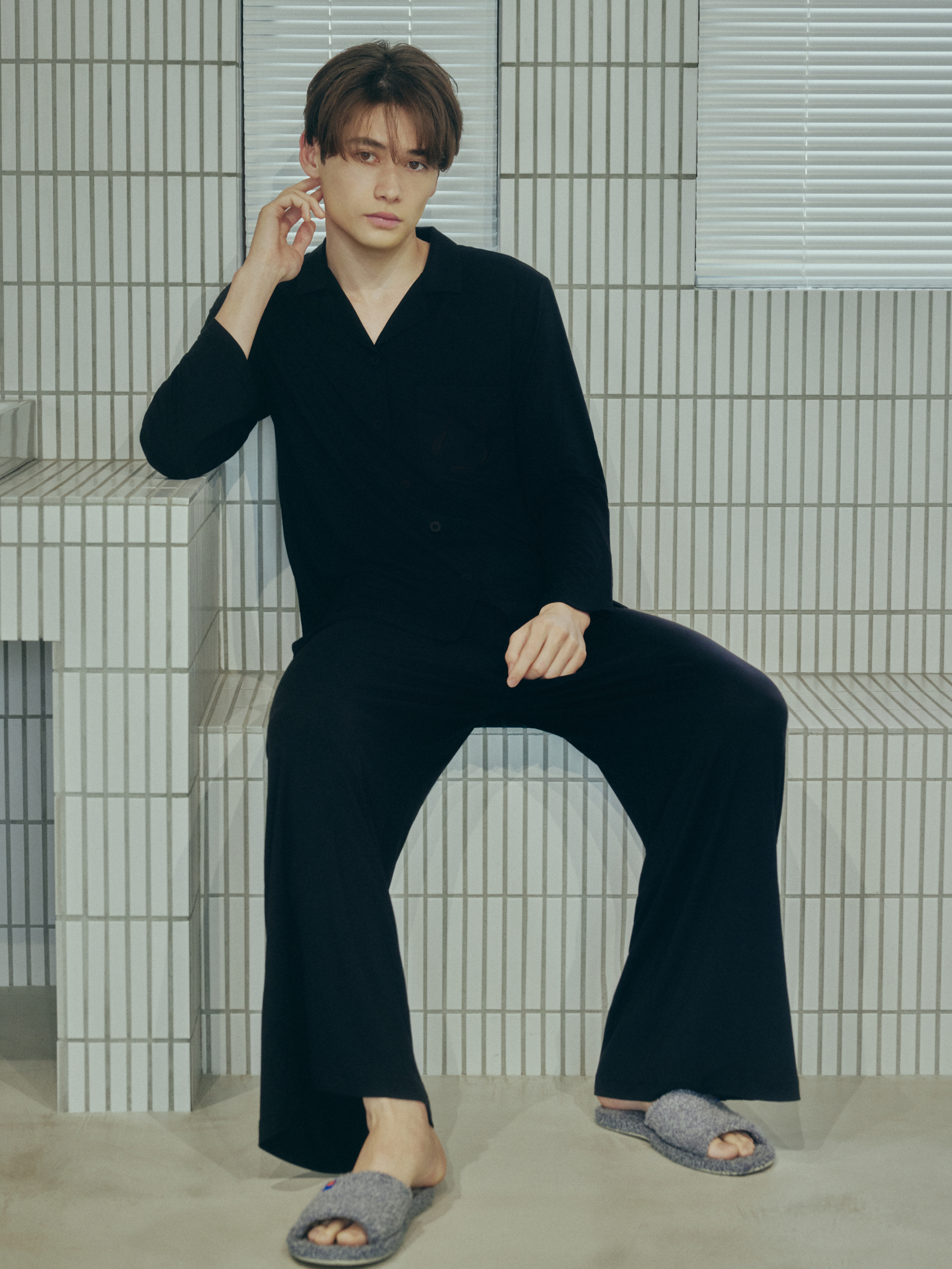 黒いAMBIENTパジャマを着た男性モデルの全身写真