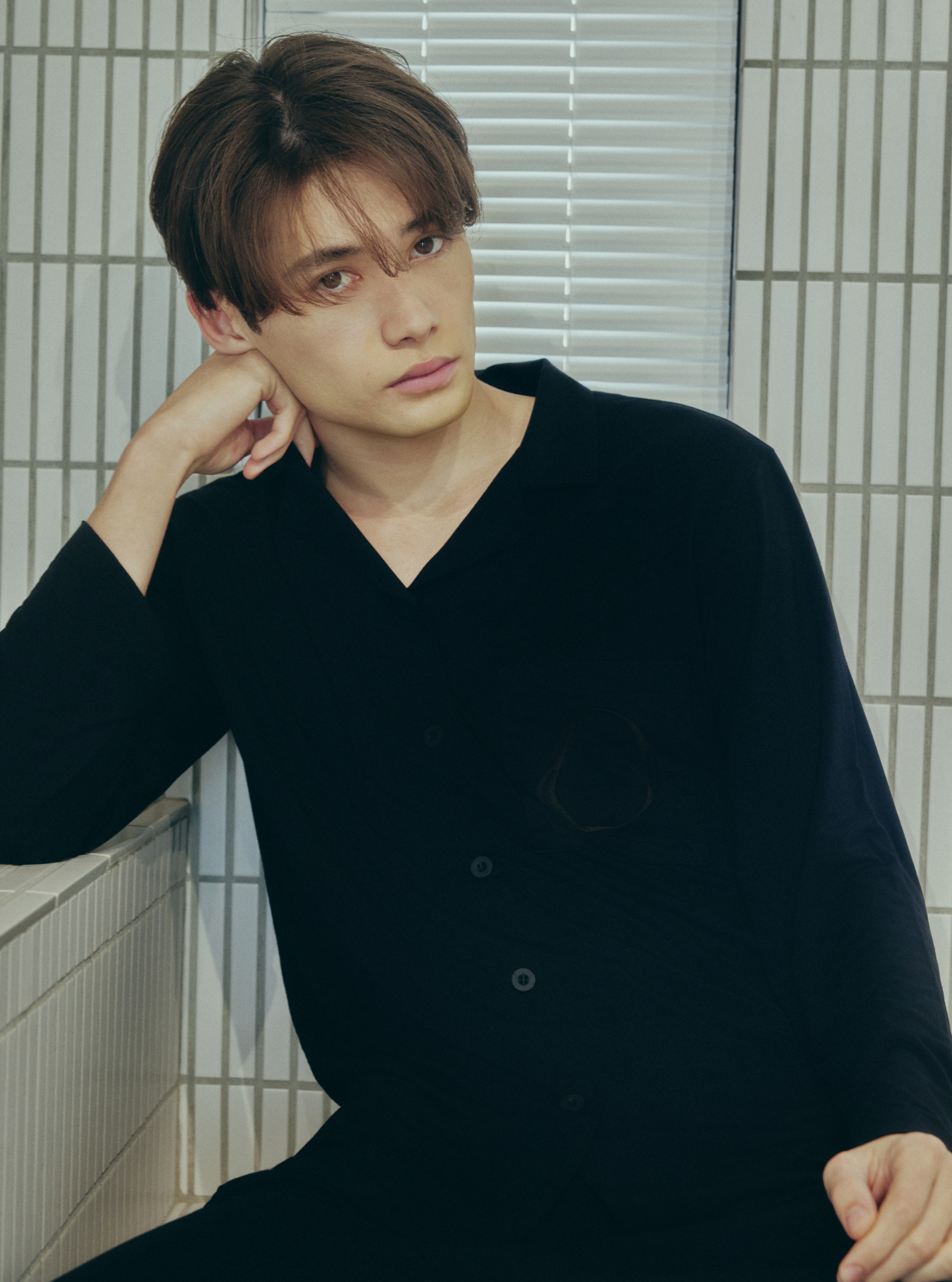 黒いAMBIENTパジャマを着て座る男性